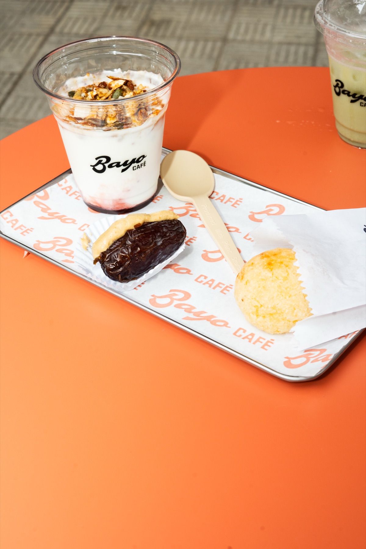 Iogurte com granola, tâmara recheada e pão de queijo em bandeja BAYO